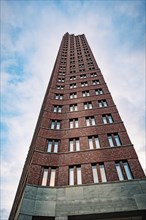 View upwards along the facade of a slender brick tower block, Berlin, Germany, Europe