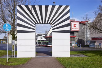 La Porta Aperta, sculpture by artist Marcello Morandini with bus station and Kaufland multi-storey