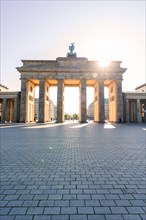 The Brandenburg Gate on a sunny day with sunbeams shining through the pillars, Berlin, Germany,