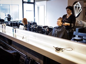 Valentyna Vysotska, hairdresser from Ukraine, combs her customer's hair, taken at the hairdressing