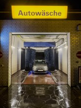 View of Fiat 500 in car wash at night with rotating brushes textile brushes for automatic machine