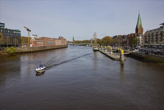 Weser with Martinianleger, Teerhof, Weser promenade, St. Martini church and motorboat in Bremen,