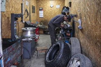 Workshop, man repairing a hole in a car tyre, Kyrgyzstan, Asia