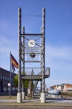 Viewing platform with clock and German flag in front of the harbour basin of the Oat in Husum,