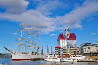 Sailing ship, small boats and a high-rise building in a harbour in Gothenburg, Sweden, Europe