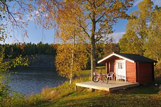 Small hut and a bicycle by a lake, foliage colouring, holiday mood, Hoegbyn, Dalsland Canal,