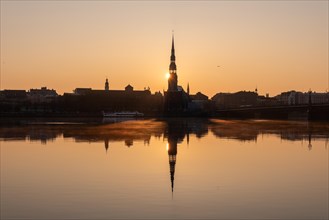 Sunrise behind St Peter's Church on the Daugava River, Riga, Latvia, Europe