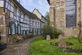 Half-timbered houses and St George's Church with historic graves and gravestones on the church