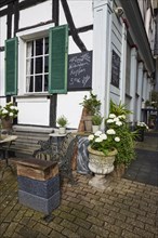Wooden bench and small table with flowers at a cafe in Hattingen, Ennepe-Ruhr-Kreis, North