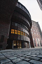 Historic brick building with characteristic arched windows and paved forecourt, Berlin, Germany,