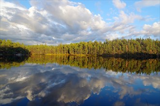 Clouds reflected in a calm lake, foliage colouring, Bullaren, Bohulaen. Sweden