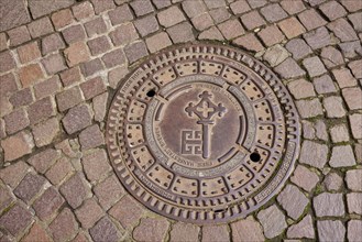 Manhole cover with the Bremen key on a paved square in Bremen, Hanseatic city, state of Bremen,