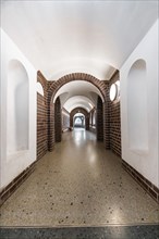 Elongated corridor in vaulted construction with brick walls and discreet lighting, Botanical