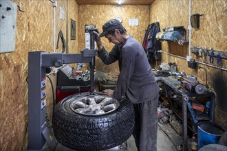 Workshop, man repairing a hole in a car tyre, Kyrgyzstan, Asia