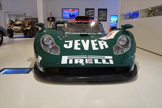 PORSCHE 911 GTI 98, A green Porsche racing car with Jever and Pirelli advertising in a museum,
