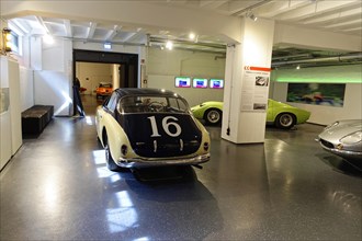 White vintage racing car with the number 16 in a showroom full of classic cars, AUTOMUSEUM