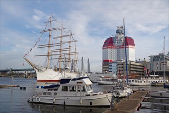 Sailing ship, small boats and a high-rise building in a harbour in Gothenburg, Sweden, Europe