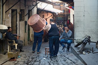 Coppersmith carrying a copper basin on his head, Gaziantep bazaar, Turkey, Asia