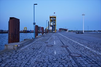 Pier with cobblestones and ferry dock in the harbour of Dagebuell, district of Nordfriesland,