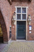 House entrance with old door, windows and two lions bearing a coat of arms with the key of Bremen,