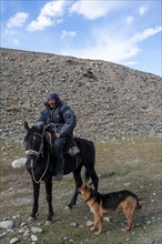 Nomadic life on a plateau, shepherd on horse with dog, Tian Shan Mountains, Jety Oguz, Kyrgyzstan,