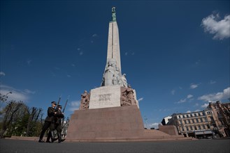 Two soldiers march in front of the Freedom Monument in Riga, Latvia, Europe