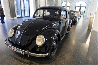 A shiny black Volkswagen Beetle parked in an exhibition hall, AUTOMUSEUM PROTOTYP, Hamburg,