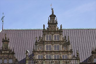 Gable with windows and roof of the historic Bremen Town Hall against a blue sky in Bremen,