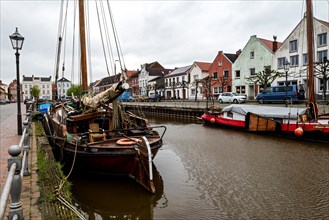 Old ships in the old harbour in the small town of Weener, at the back left historic Baerchen villa,
