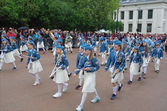 A marching band with young people walks the streets to the castle, folklore, bank holidays 17 May,
