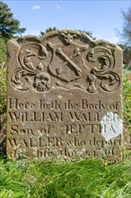Old headstone in churchyard with skull, cross bones, sand timer, Ramsholt, Suffolk, England, UK