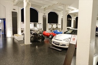 View of a collection of various vintage cars in an exhibition room for historic vehicles,