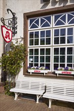 Swan pharmacy with benches and flower boxes in the city centre of Husum, Nordfriesland district,