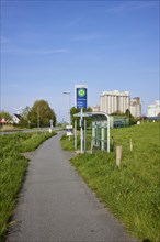 Bus stop Fischersiedlung with cycle path and silos in the harbour of Husum, district of