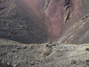 A rocky volcanic landscape with a red crater and barren terrain, barren landscape with roads,