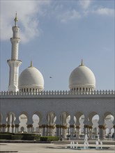 White mosque complex with elegant domes and a minaret under a clear sky, beautiful mosque with
