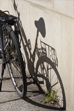 Bicycle with shadow on a house wall, Germany, Europe