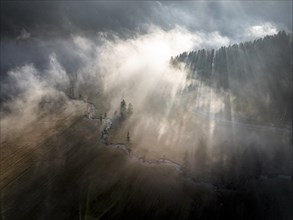 Aerial view, dramatic mood, sun shining through forest and fog, Ammergau, Upper Bavaria, Bavaria,