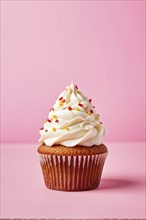 Cupcake with swirls of buttercream frosting in vanilla against pastel pink background, AI generated