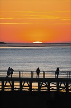 Silhouettes of several people on the pier free canal, jetty, couple and individuals watching the