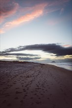 Sunset on the beach, purple sky and a calm sea. Taken in Papamoa Beach, New Zealand, Oceania
