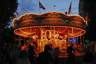 Children's carousel with evening lighting at Queens Walk on the Thames, London, England, Great