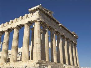 Ancient Greek temple ruins with Doric columns and a sky blue backdrop, historical columns and ruins