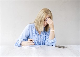 Tired woman touching forehead having headache migraine