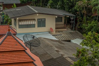 Rooftops and satellite dishes in southeast asian neighborhood. Taken from fourth floor hotel window