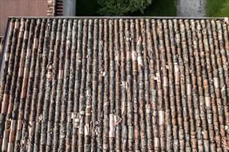 Bird's-eye view of worn terracotta tiles covering residential rooftops