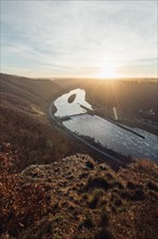 Sunrise over a river bend with hills and trees. Niederfell Germany