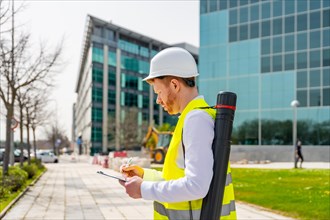 Horizontal photo with copy space of an engineer working writing notes in an urban construction site