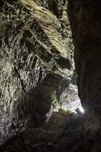 Hiker explores Obstans ice cave in Alta Pusteria, Carnic Alps, East Tyrol, Austria, Europe