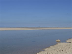 A quiet beach with a clear blue sky and peaceful sea view, wide sky on the lonely North Sea beach